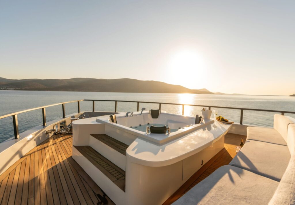 Motor Yacht Jakuzi alanında deniz manzarası eşliğinde açık havada lüks jakuzi keyfi sunan modern motoryat.